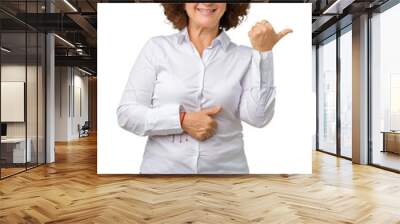 Beautiful middle ager senior businees woman over isolated background smiling with happy face looking and pointing to the side with thumb up. Wall mural