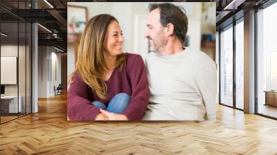 Beautiful romantic couple sitting together on the floor at home Wall mural