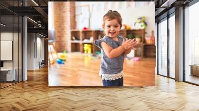 Beautiful toddler standing on the floor applauding and smiling at kindergarten Wall mural