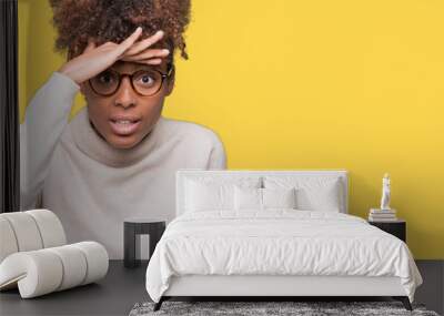 Beautiful young african american woman wearing glasses over isolated background very happy and smiling looking far away with hand over head. Searching concept. Wall mural