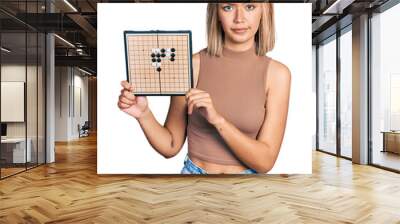 Beautiful young blonde woman holding asian go game board skeptic and nervous, frowning upset because of problem. negative person. Wall mural