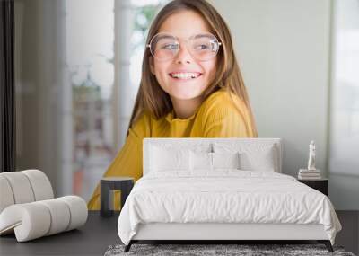 Beautiful young girl kid wearing glasses smiling looking side and staring away thinking. Wall mural