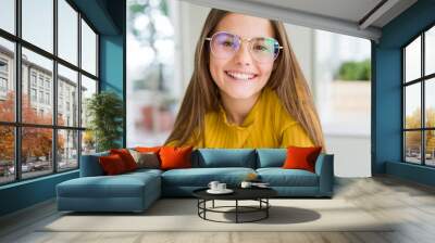 Beautiful young girl kid wearing glasses smiling looking side and staring away thinking. Wall mural