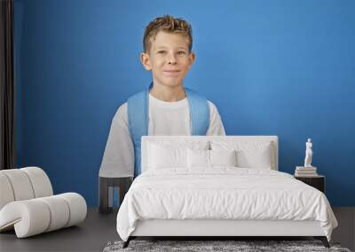 Blond boy student smiling confident over isolated blue background Wall mural