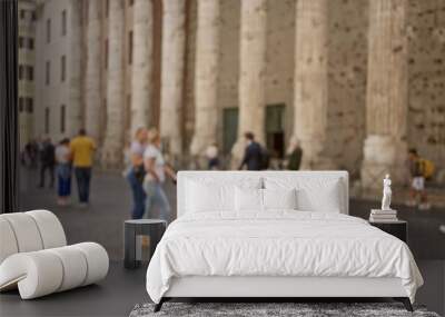 Blurred street scene in rome featuring people walking near historic buildings with defocused columns and urban ambiance. Wall mural