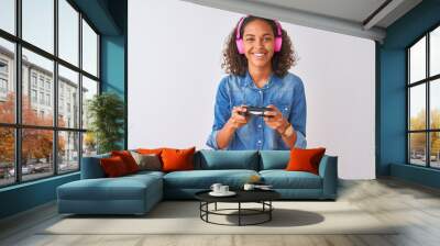 Brazilian gamer woman playing video game using headphones over isolated white background with a happy face standing and smiling with a confident smile showing teeth Wall mural