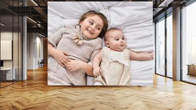 Brother and sister smiling confident lying together on bed at bedroom Wall mural