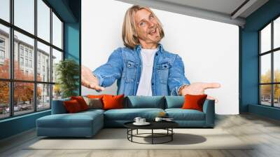 Caucasian man with blond long hair wearing casual denim jacket smiling cheerful offering hands giving assistance and acceptance. Wall mural