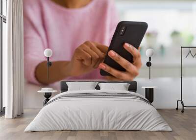 Close up of african american woman using smartphone and smiling Wall mural