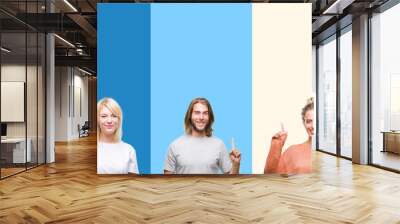 Collage of casual young people over colorful stripes isolated background showing and pointing up with finger number one while smiling confident and happy. Wall mural