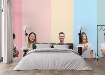 Collage of different ethnics young people wearing white t-shirt over colorful isolated background cheerful with a smile of face pointing with hand and finger up to the side with happy and natural Wall mural