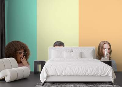 Collage of group of young people over colorful vintage isolated background bored yawning tired covering mouth with hand. Restless and sleepiness. Wall mural