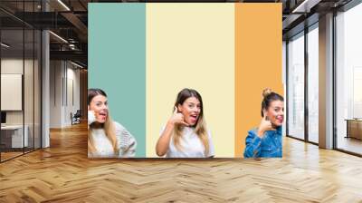 Collage of young beautiful woman over colorful vintage isolated background smiling doing phone gesture with hand and fingers like talking on the telephone. Communicating concepts. Wall mural