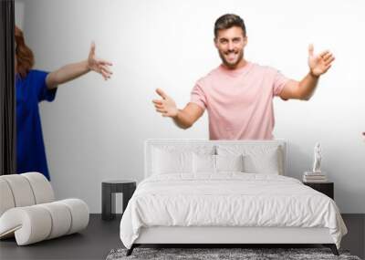 Composition of african american, hispanic and caucasian group of people over isolated white background looking at the camera smiling with open arms for hug. Cheerful expression embracing happiness. Wall mural