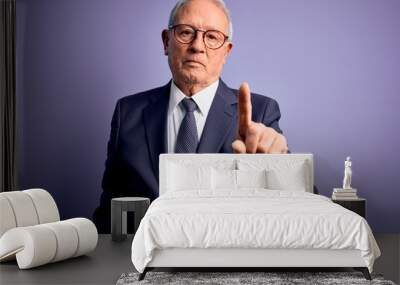 Grey haired senior business man wearing glasses and elegant suit and tie over purple background Pointing with finger up and angry expression, showing no gesture Wall mural