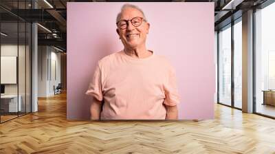 Grey haired senior man wearing glasses standing over pink isolated background with a happy and cool smile on face. Lucky person. Wall mural