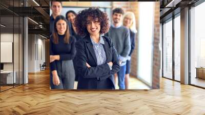 Group of business workers smiling happy and confident. Posing together with smile on face looking at the camera, young beautiful woman with crossed arms at the office Wall mural