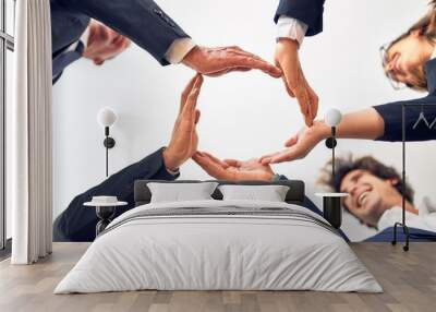 Group of business workers smiling happy and confident. Standing on a circle with smile on face doing symbol with hands together at the office. Wall mural