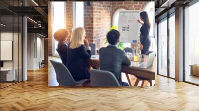 Group of business workers working together in a meeting. One of them making presentation to colleagues at the office Wall mural