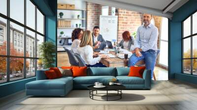 Group of business workers working together. Middle age handsome businessman standing smiling happy looking at the camera at the office Wall mural