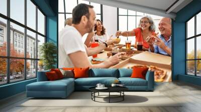 Group of middle age people smiling happy eating italian pizza sitting on the table at home Wall mural