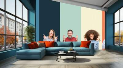 Group of people over vintage colors background smiling crossing fingers with hope and eyes closed. Luck and superstitious concept. Wall mural