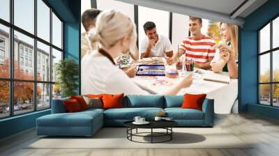 Group of people smiling happy drawing sitting on the table at art studio. Wall mural