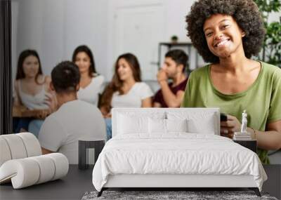 Group of young friends eating italian sitting on the sofa. Woman smiling and using smartphone at home. Wall mural