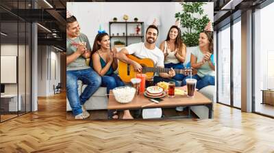 Group of young hispanic friends having birthday party playing spanish guitar at home. Wall mural