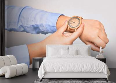 Hand of caucasian young businesswoman wearing wristwatch. Catching watch with two fingers over isolated white background Wall mural