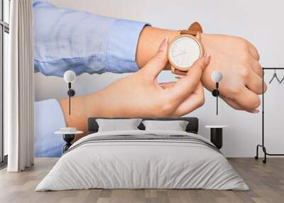 Hand of caucasian young businesswoman wearing wristwatch. Catching watch with two fingers over isolated white background Wall mural