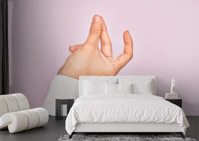 Hand of caucasian young man showing fingers over isolated pink background snapping fingers for success, easy and click symbol gesture with hand Wall mural