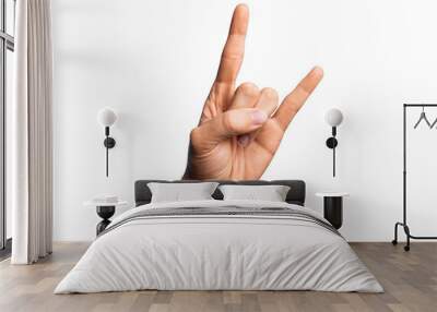 Hand of caucasian young man showing fingers over isolated white background gesturing rock and roll symbol, showing obscene horns gesture Wall mural