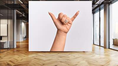 Hand of caucasian young woman gesturing Hawaiian shaka greeting gesture, telephone and communication symbol Wall mural