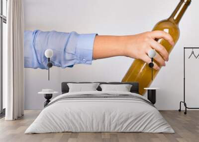 Hand of caucasian young woman holding empty glass botlle of wine over isolated white background Wall mural