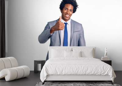 Handsome african american man with afro hair wearing business jacket doing happy thumbs up gesture with hand. approving expression looking at the camera showing success. Wall mural