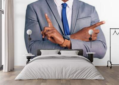 Handsome african american man with afro hair wearing business jacket pointing to both sides with fingers, different direction disagree Wall mural