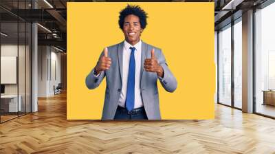 Handsome african american man with afro hair wearing business jacket success sign doing positive gesture with hand, thumbs up smiling and happy. cheerful expression and winner gesture. Wall mural