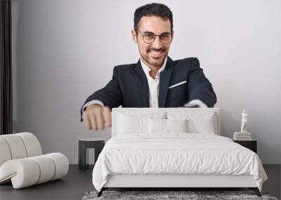 Handsome business hispanic man standing over white background pointing to you and the camera with fingers, smiling positive and cheerful Wall mural