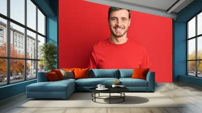 Handsome caucasian man wearing casual red tshirt with a happy and cool smile on face. lucky person. Wall mural