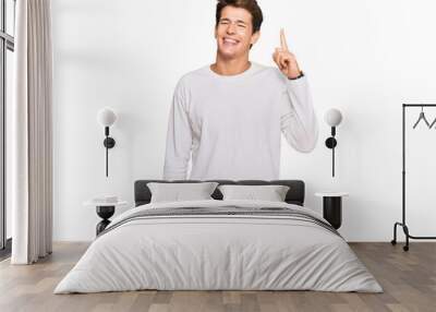 Handsome caucasian man wearing casual white sweater showing and pointing up with finger number one while smiling confident and happy. Wall mural