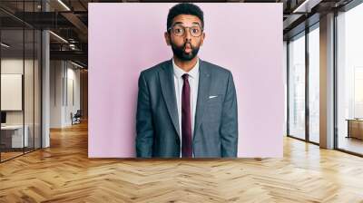 Handsome hispanic business man with beard wearing business suit and tie making fish face with lips, crazy and comical gesture. funny expression. Wall mural