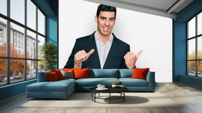 Handsome hispanic man wearing business clothes pointing to the back behind with hand and thumbs up, smiling confident Wall mural