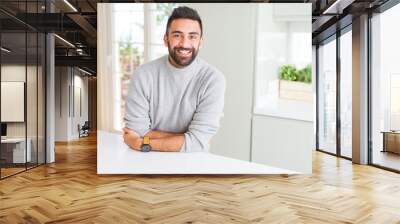 Handsome hispanic man wearing casual sweater at home happy face smiling with crossed arms looking at the camera. Positive person. Wall mural