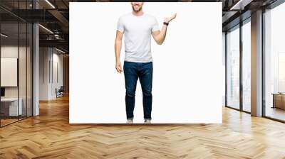 Handsome man wearing casual white t-shirt smiling cheerful presenting and pointing with palm of hand looking at the camera. Wall mural