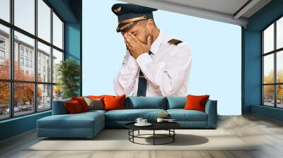 Handsome man with beard wearing airplane pilot uniform with sad expression covering face with hands while crying. depression concept. Wall mural