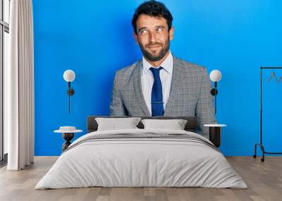 Handsome man with beard wearing business suit and tie smiling looking to the side and staring away thinking. Wall mural