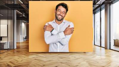 Handsome man with beard wearing casual white t shirt hugging oneself happy and positive, smiling confident. self love and self care Wall mural