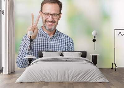 Handsome middle age elegant senior business man wearing glasses over isolated background showing and pointing up with fingers number two while smiling confident and happy. Wall mural