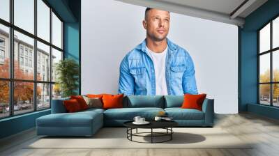 Handsome muscle man wearing casual denim jacket smiling looking to the side and staring away thinking. Wall mural